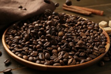 Pouring coffee beans onto plate at table, closeup