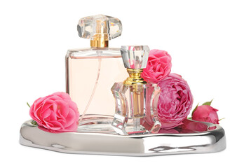 Different perfume bottles and roses isolated on white