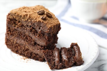 Piece of delicious chocolate cake with coffee beans on white marble table, closeup