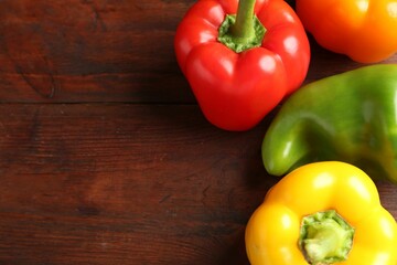 Ripe colorful bell peppers on wooden table, closeup. Space for text
