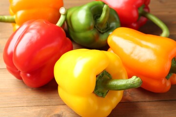 Ripe colorful bell peppers on wooden table, closeup