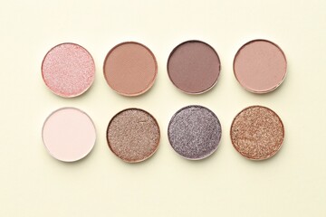 Beautiful eyeshadow refill pans on beige background, flat lay