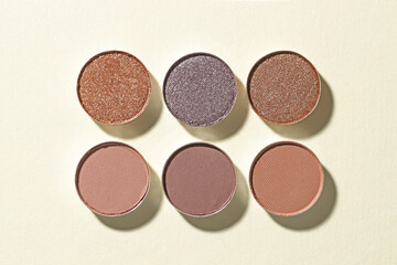 Beautiful eyeshadow refill pans on beige background, flat lay
