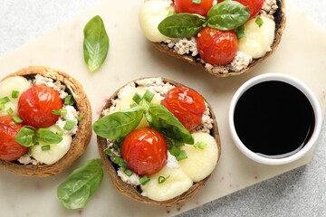 Tasty stuffed mushrooms served on light table, top view