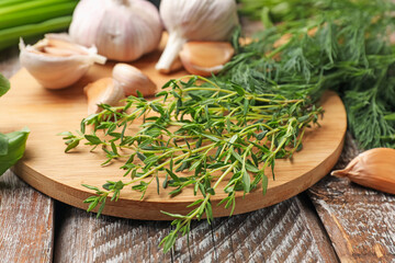 Different fresh herbs and spices on wooden table, closeup