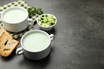 Tasty cucumber soup served on grey table. Space for text