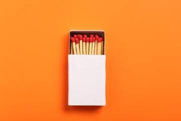 Matches in box on orange background, top view. Mockup for design