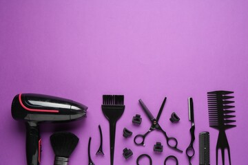 Different hairdresser's tools on violet background, flat lay. Space for text