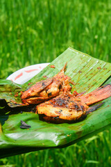 Close up of grilled fish cooked with tomatoes and spicy red chilies