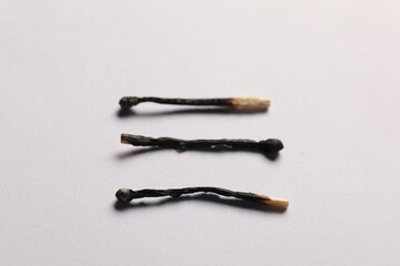Burnt matches on grey background, closeup view