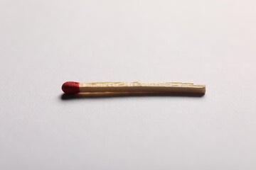 One match with red head on grey background, closeup