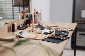 Different makeup products and brush on vanity indoors