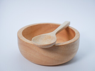 Minimalist photo of a small wooden bowl with a spoon, on a bright white background.