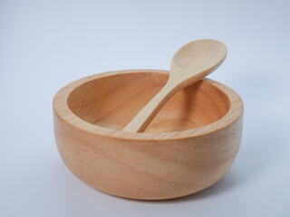 Simple composition of an empty wooden bowl with a matching spoon placed inside.