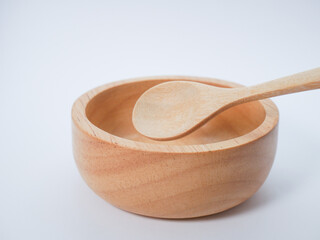 Minimalist photo of a small wooden bowl with a spoon, on a bright white background.