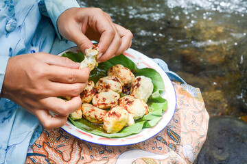 Close up of a woman eating basreng and typical Indonesian nyemek noodles