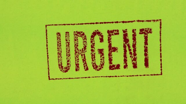 Close-up of a red ink stamp sign that reads Urgent on a green background.