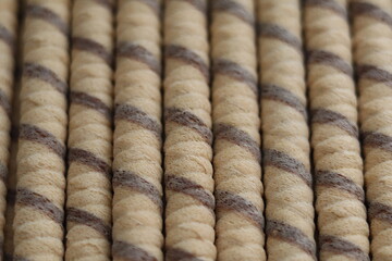 Brown and beige twisted rope rolls lined up in a neat arrangement on a flat surface in a well-lit space