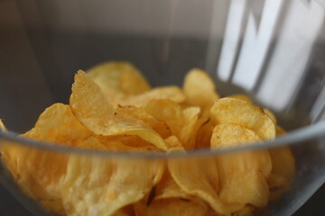 Crispy potato chips in a clear bowl ready for snacking during a casual gathering in the afternoon