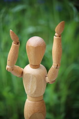 Wooden man with raised hands