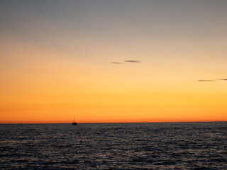 Naklejka premium sunset with sailboat over the sea