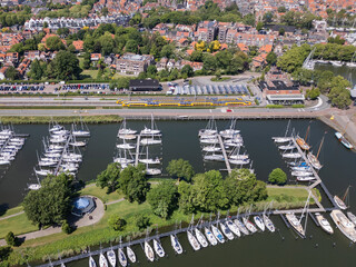 Aerial drone footage of train station and marina port in Dutch city Enkhuizen. Boats yachts Netherlands harbor water Ijsselmeer on sunny summer day