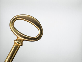 Golden metal key from an old chest on the left on a white background macro top view. High quality photo