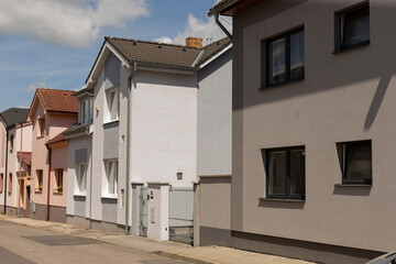 The image depicts a series of residential houses arranged in a line along a street, highlighting...