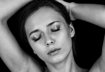 Naklejka premium Beautiful woman posing with closed eyes and hands on head