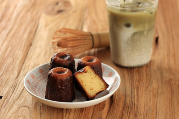 Caneles de bordeaux, Traditional French Sweet Dessert Served with Green Tea Matcha Latte,