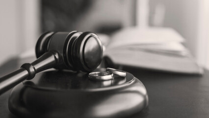 Black and white dramatic judge gavel and wedding rings for divorce proceedings. Mallet of a judge...
