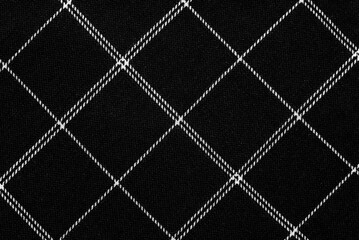The texture of linen fabric in a large cell of black and white. Scottish tailoring material. checkered fabric