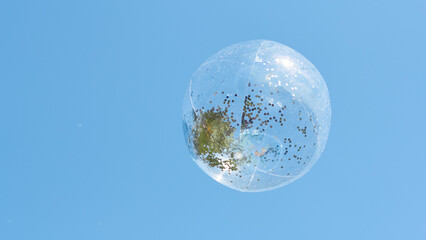 Bubble floating in a clear sky with natural elements inside