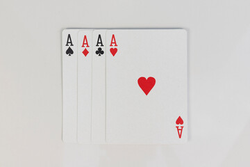 Four aces playing cards of spades, diamonds, clubs and hearts on white background