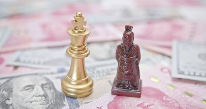US-China trade relations, geopolitical tensions, tariff war resolution : A king chess piece paired with a Chinese emperor warrior figure rests on a backdrop of US dollar and Chinese yuan banknotes.