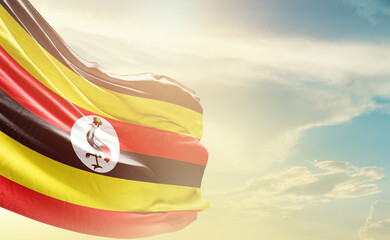 Uganda flag wave in soft clouds. National flag beautifully waving in the sky. Uganda national flag for independence day.