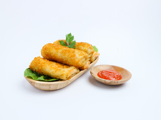 Indonesian risol mayo served on lettuce in a wooden tray with chili sauce in a wooden bowl, presented on a white background