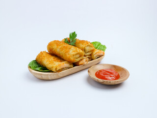 Indonesian risol mayo served on lettuce in a wooden tray with chili sauce in a wooden bowl, presented on a white background