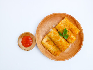 Crispy Indonesian risol mayo rolls served on a wooden plate with chili sauce in a small bowl, isolated on a white background