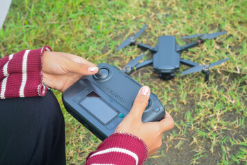 Young Asian woman flying a drone in nature