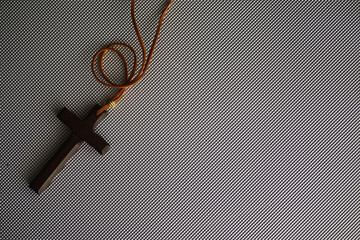 Wooden Cross Necklace on Textured Surface - Religious Symbol of Faith and Spirituality