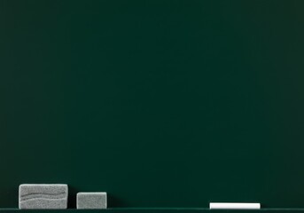 Green chalkboard with chalk and erasers on the ledge