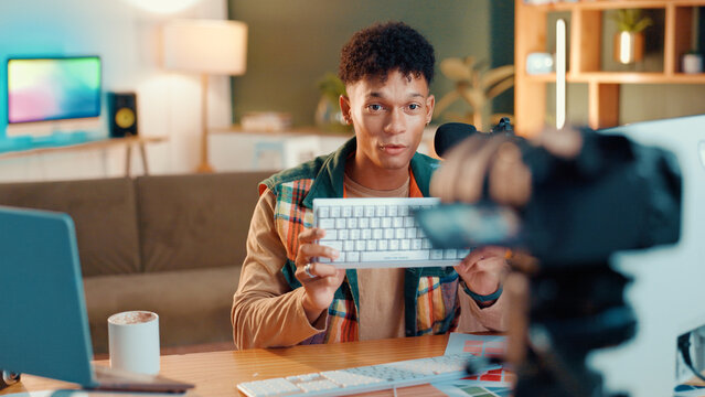 Man, keyboard and recording with video camera for online streaming, gamer tips or tutorial at home. Male person, influencer or videographer with technology for vlog, gaming advice or review at house
