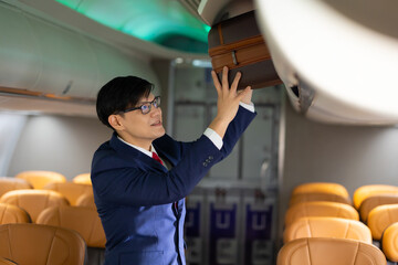 steward working : Asian male steward working in airplane on board. Flight attendant