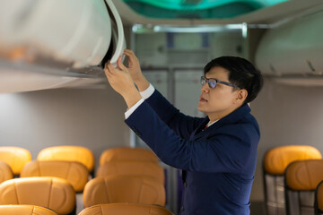 steward working : Asian male steward working in airplane on board. Flight attendant