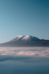 Fototapeta premium breathtaking view of mount kilimanjaro emerging from sea of clouds majestic peak and its snowcapped summit