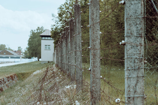 Barbed wire fence surrounds historic site in somber location reflecting past events