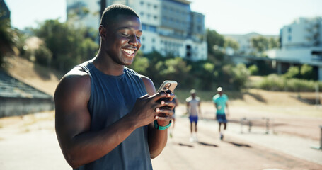 Outdoor, man and chat with smartphone for fitness, online communication and smile on application. Stadium, male person and athlete with mobile for typing message, social media and break for exercise