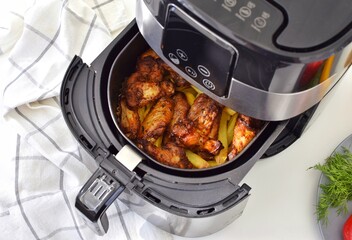Cooking potatoes with chicken in a deep fryer. Fast and convenient.