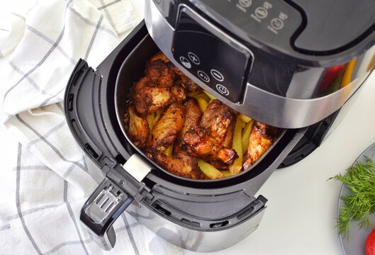 Cooking potatoes with chicken in a deep fryer. Fast and convenient.
